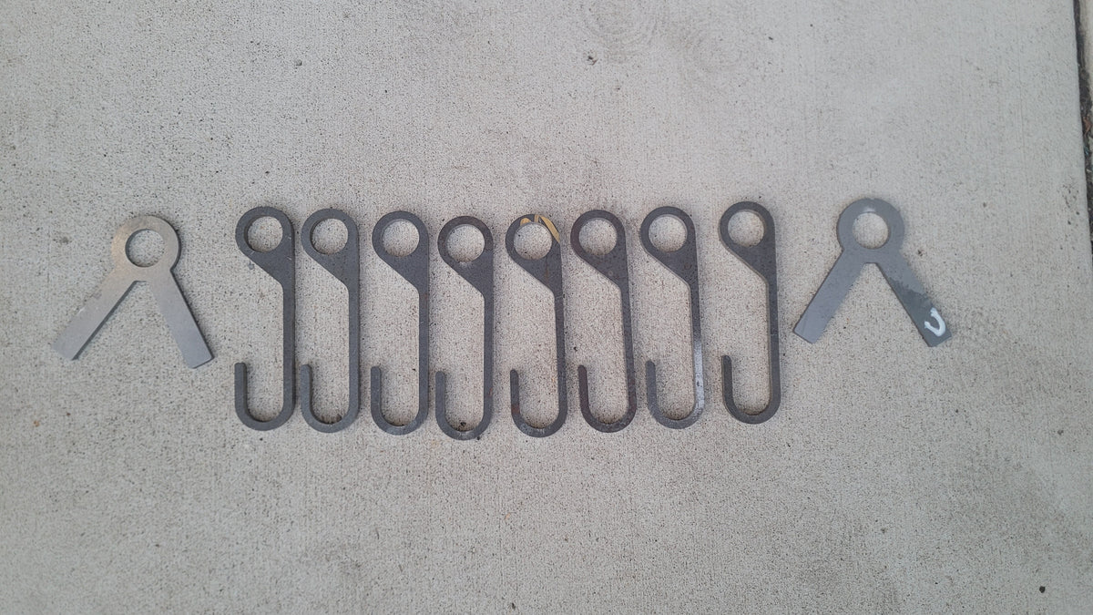 8 AR500 steel gong hooks and 2 stand ends laid out on concrete