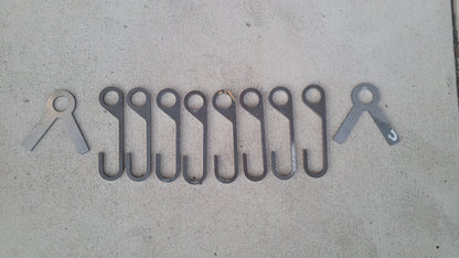 8 AR500 steel gong hooks and 2 stand ends laid out on concrete